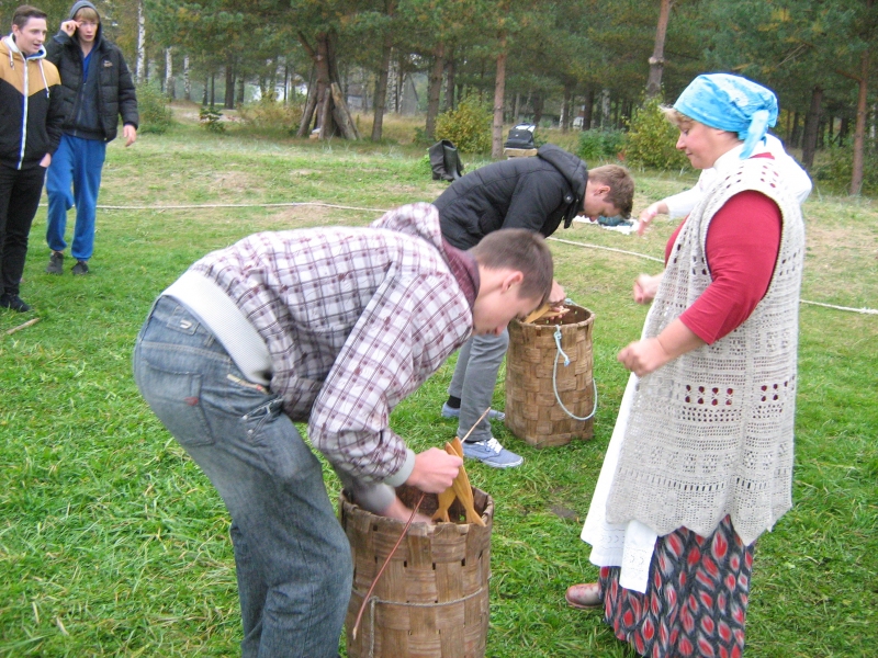 Engures novada „Dieniņās” jaunieši apgūstot zivju vēršanu, viņus māca Iveta Celkarte.