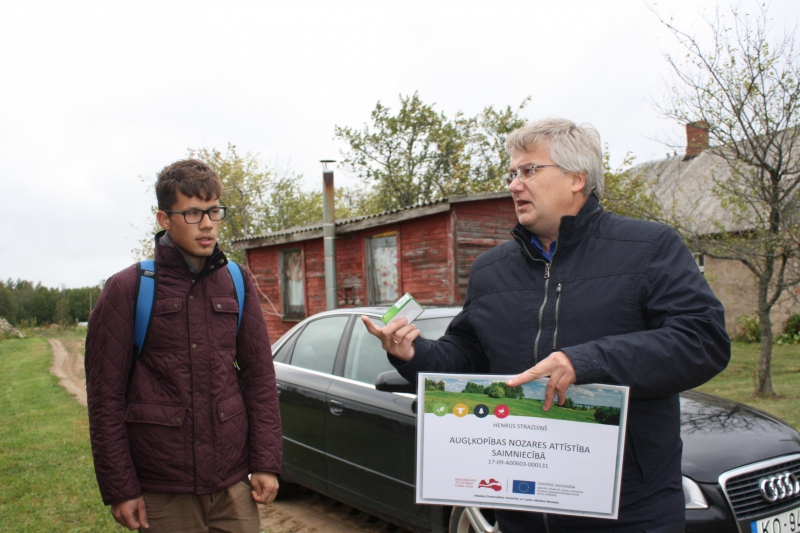 Jaunais zemnieks Henrijs Strazdiņš no LLKC Limbažu biroja vadītāja Aigara Legzdiņa saņem informatīvo plakātu par ES projekta īstenošanu